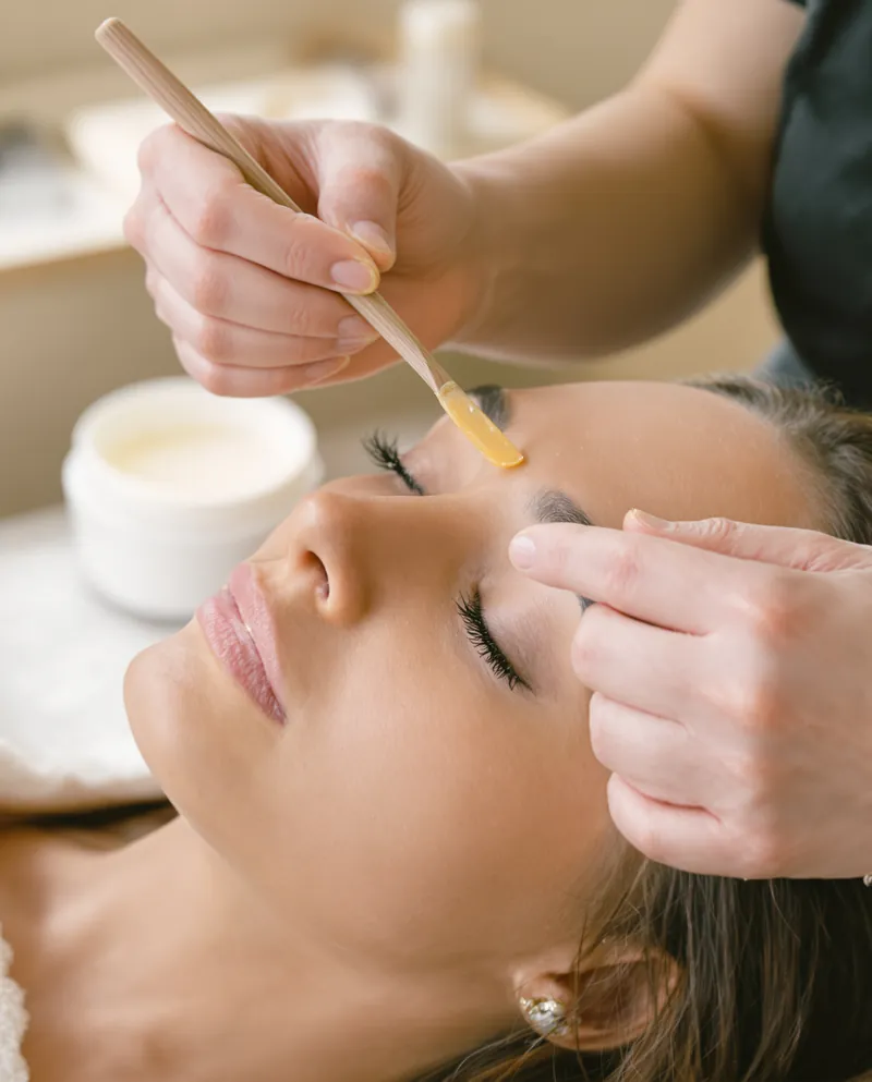 Precision brow waxing with a wooden spatula